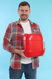 Photo of Man holding plastic canister on light blue background