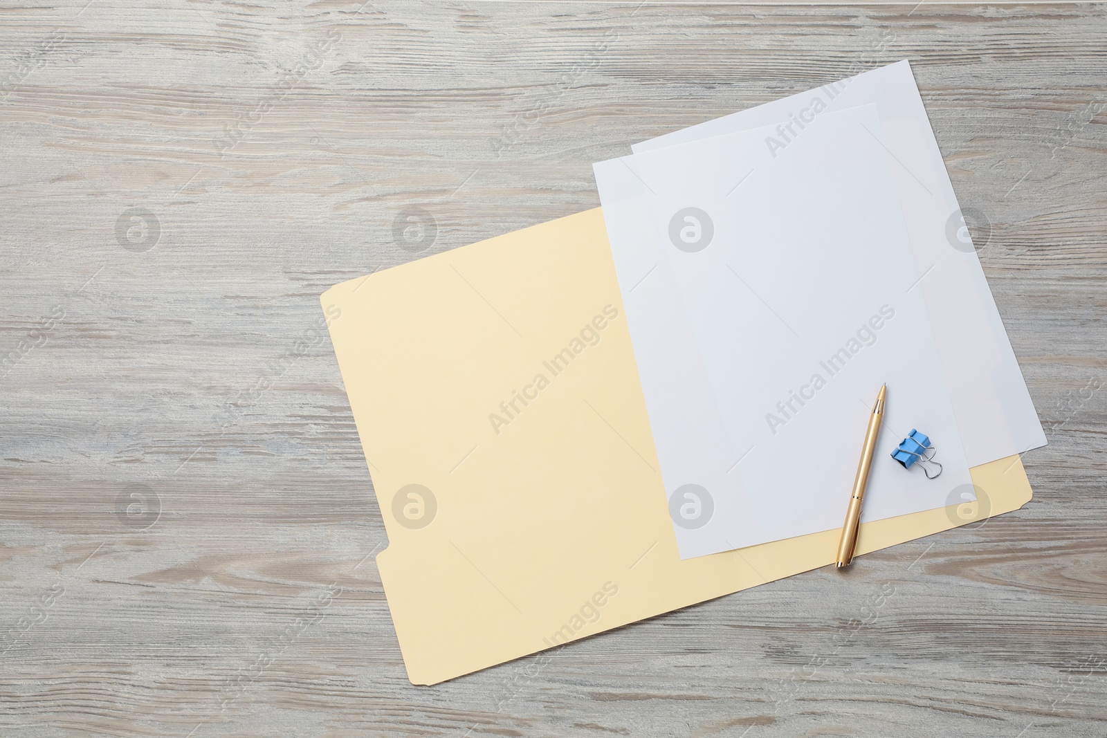 Paper file folder with blank sheets, pen and binder clip on wooden table, top view. Space for text Photo of Paper file folder with blank sheets, pen and binder clip on wooden table, top view. Space for text