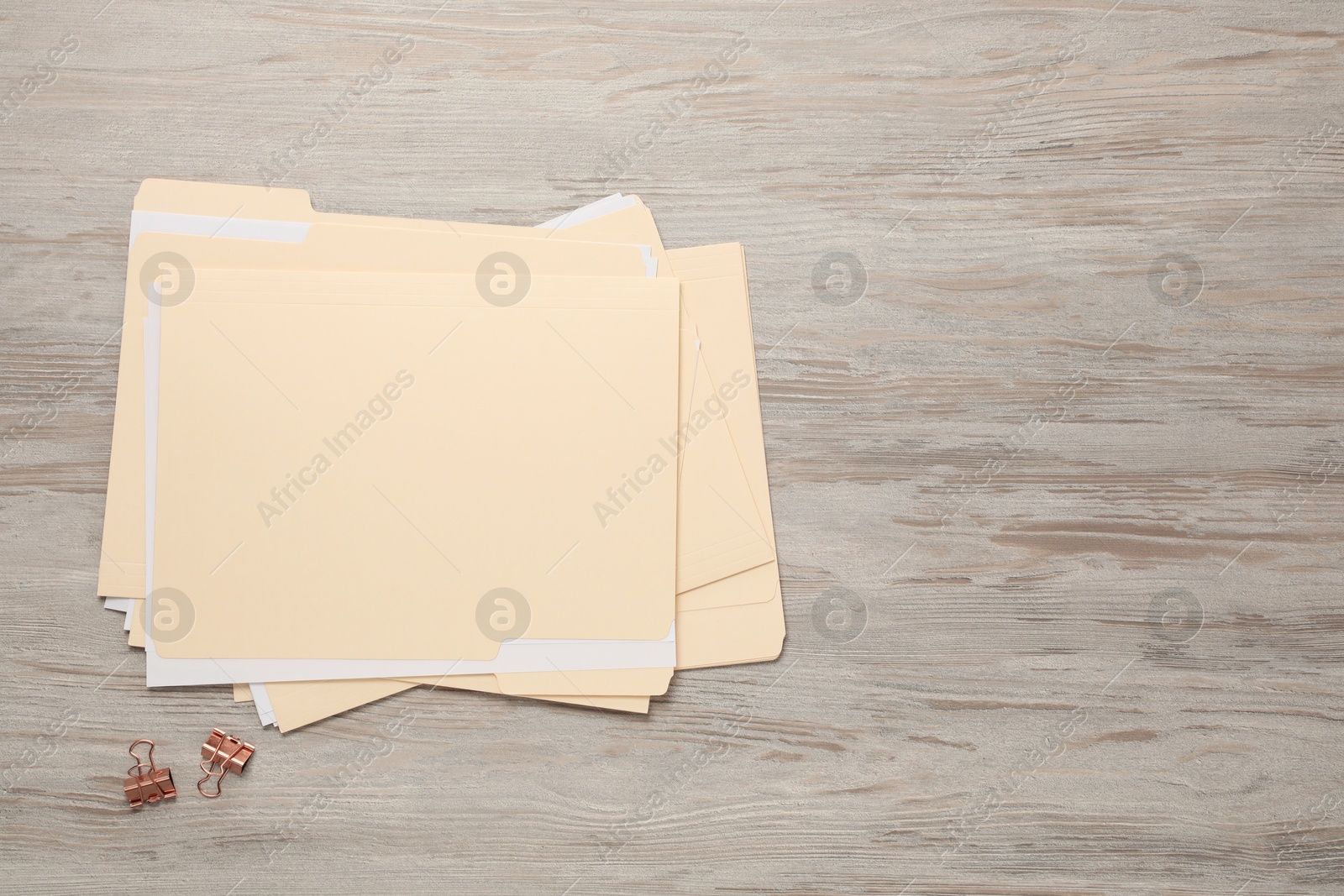File folders with papers and binder clips on wooden table, flat lay. Space for text Photo of File folders with papers and binder clips on wooden table, flat lay. Space for text