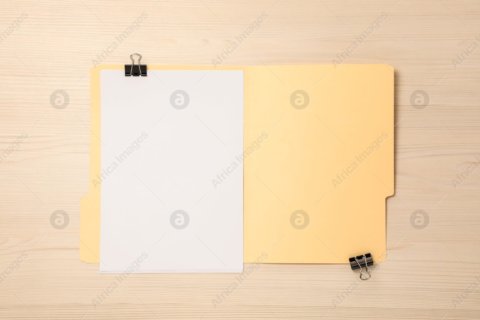 Paper file folder with blank sheets and binder clips on wooden table, top view Photo of Paper file folder with blank sheets and binder clips on wooden table, top view