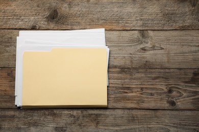 Photo of File folder with papers on wooden table, top view. Space for text