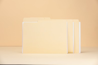 Photo of File folders with papers on pale yellow background