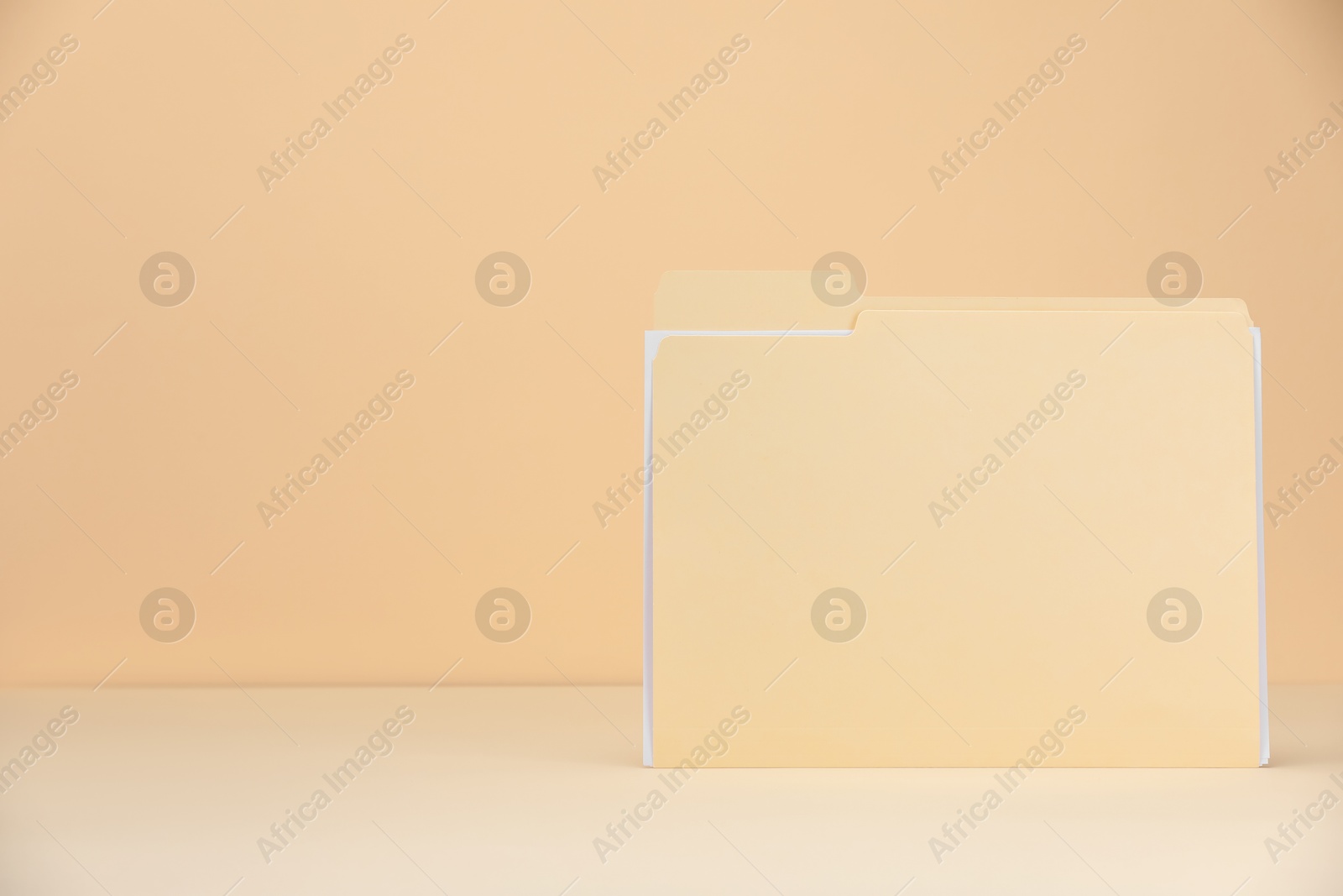 Paper file folder on pale yellow background, space for text Photo of Paper file folder on pale yellow background, space for text