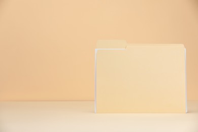 Photo of Paper file folder on pale yellow background, space for text