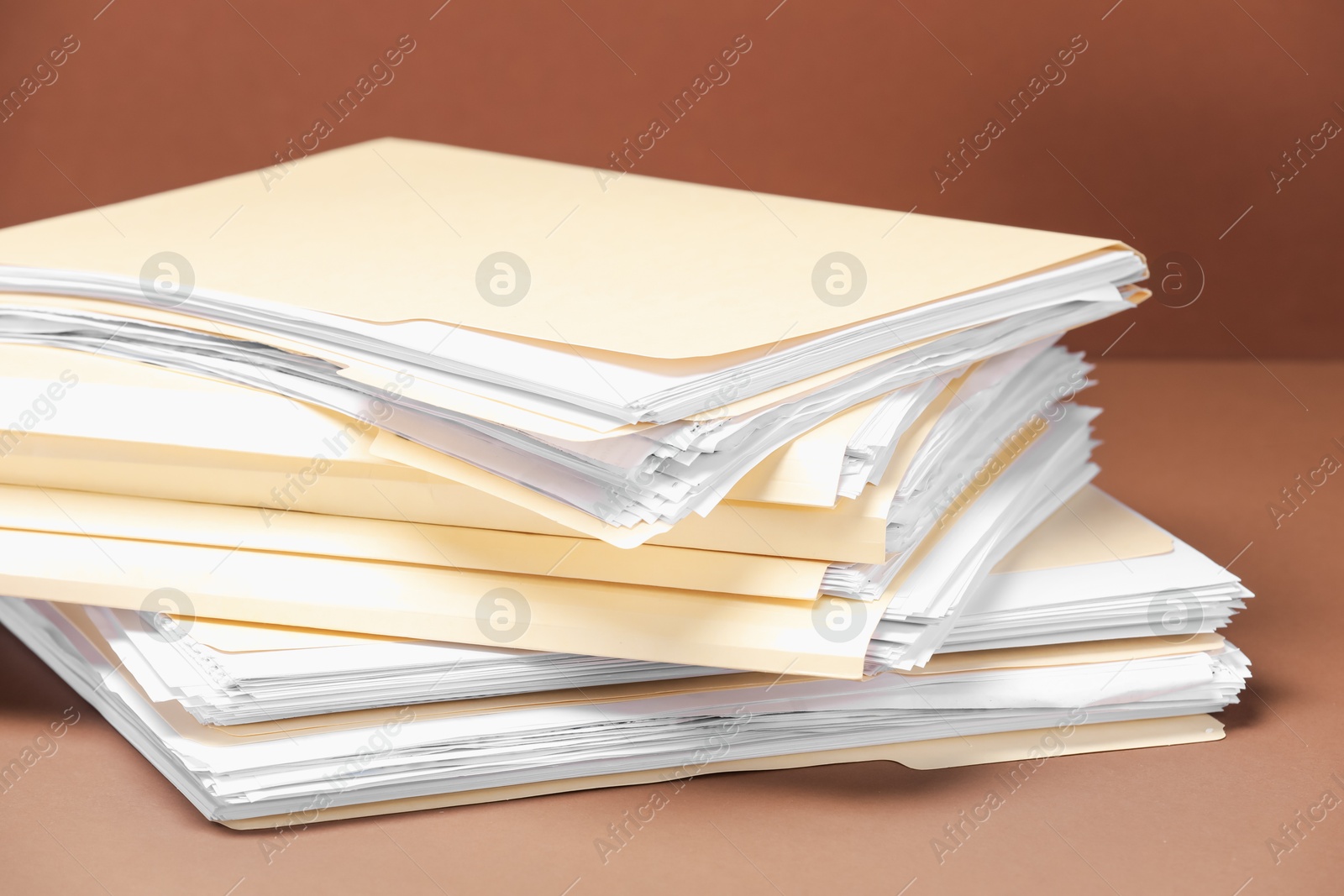 File folders with papers on brown background, closeup Photo of File folders with papers on brown background, closeup