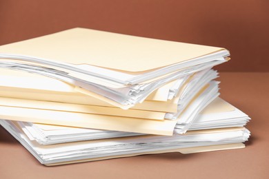 Photo of File folders with papers on brown background, closeup