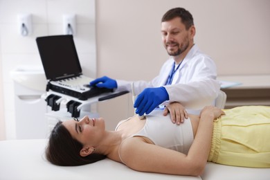 Photo of Sonographer conducting ultrasound examination of woman's heart in clinic