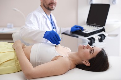 Photo of Sonographer conducting ultrasound examination of woman's heart in clinic, closeup