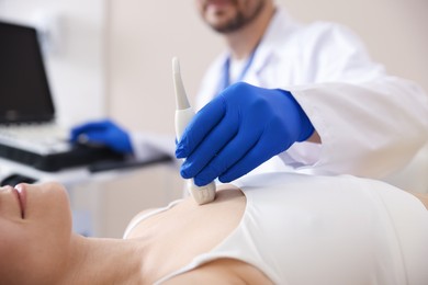 Photo of Sonographer conducting ultrasound examination of woman's heart in clinic, closeup
