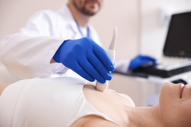 Photo of Sonographer conducting ultrasound examination of woman's heart in clinic, closeup