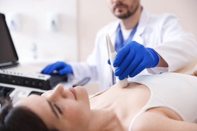 Photo of Sonographer conducting ultrasound examination of woman's heart in clinic, closeup