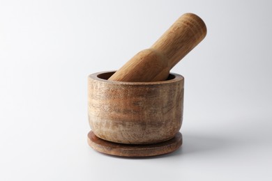 Photo of Wooden mortar with pestle on white background