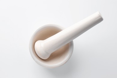 Photo of Ceramic mortar with pestle on white background, top view