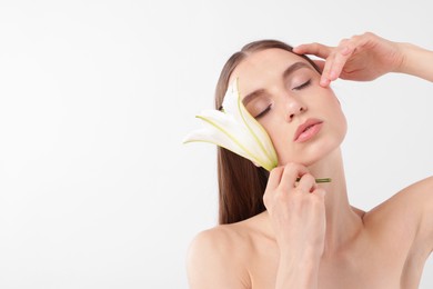 Photo of Portrait of attractive young woman with flower on white background. Space for text
