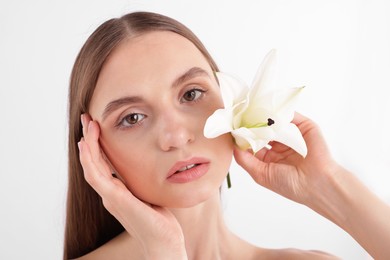 Photo of Portrait of attractive young woman with flower on white background