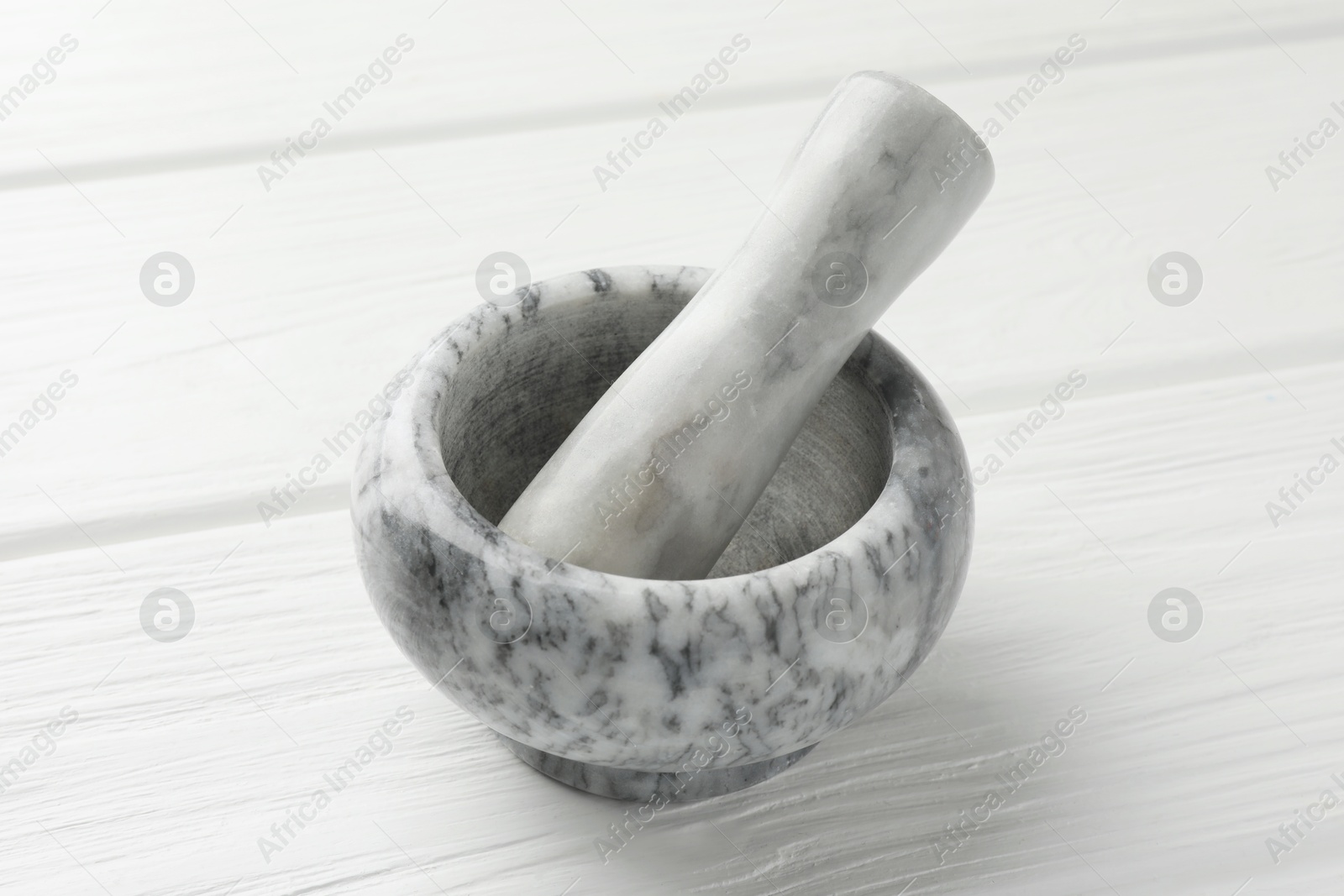 Marble mortar and pestle on white wooden table, closeup Photo of Marble mortar and pestle on white wooden table, closeup