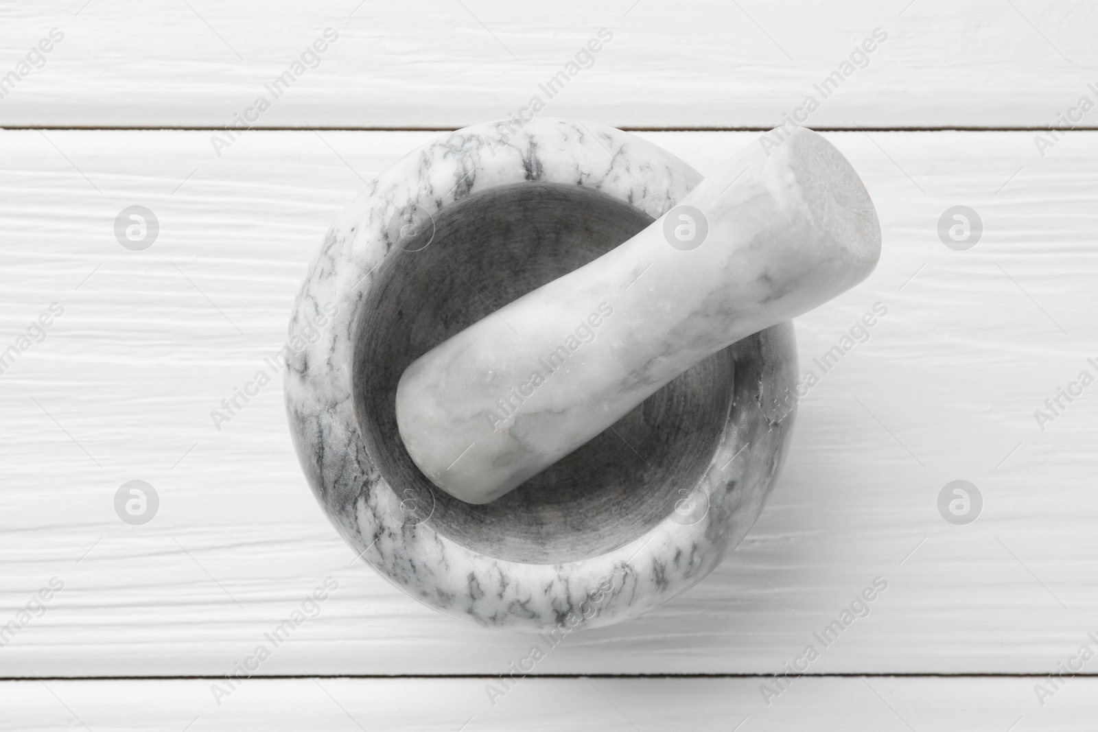 Marble mortar and pestle on white wooden table, top view Photo of Marble mortar and pestle on white wooden table, top view