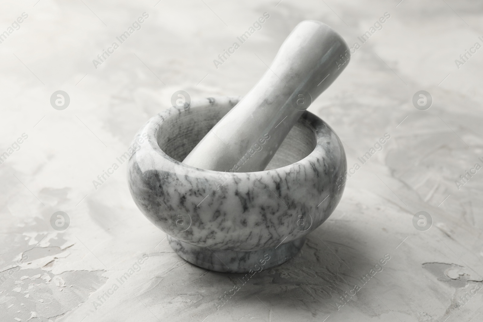 Marble mortar and pestle on grey textured table, closeup Photo of Marble mortar and pestle on grey textured table, closeup