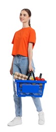 Photo of Woman with shopping basket full of products on white background