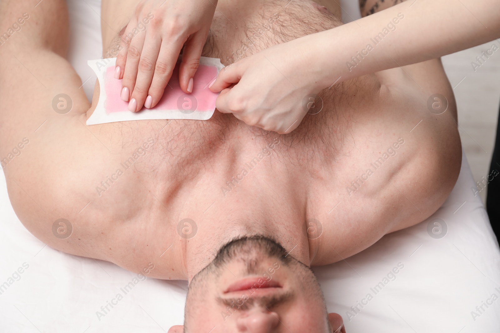 Young man undergoing wax epilation in salon, closeup Photo of Young man undergoing wax epilation in salon, closeup