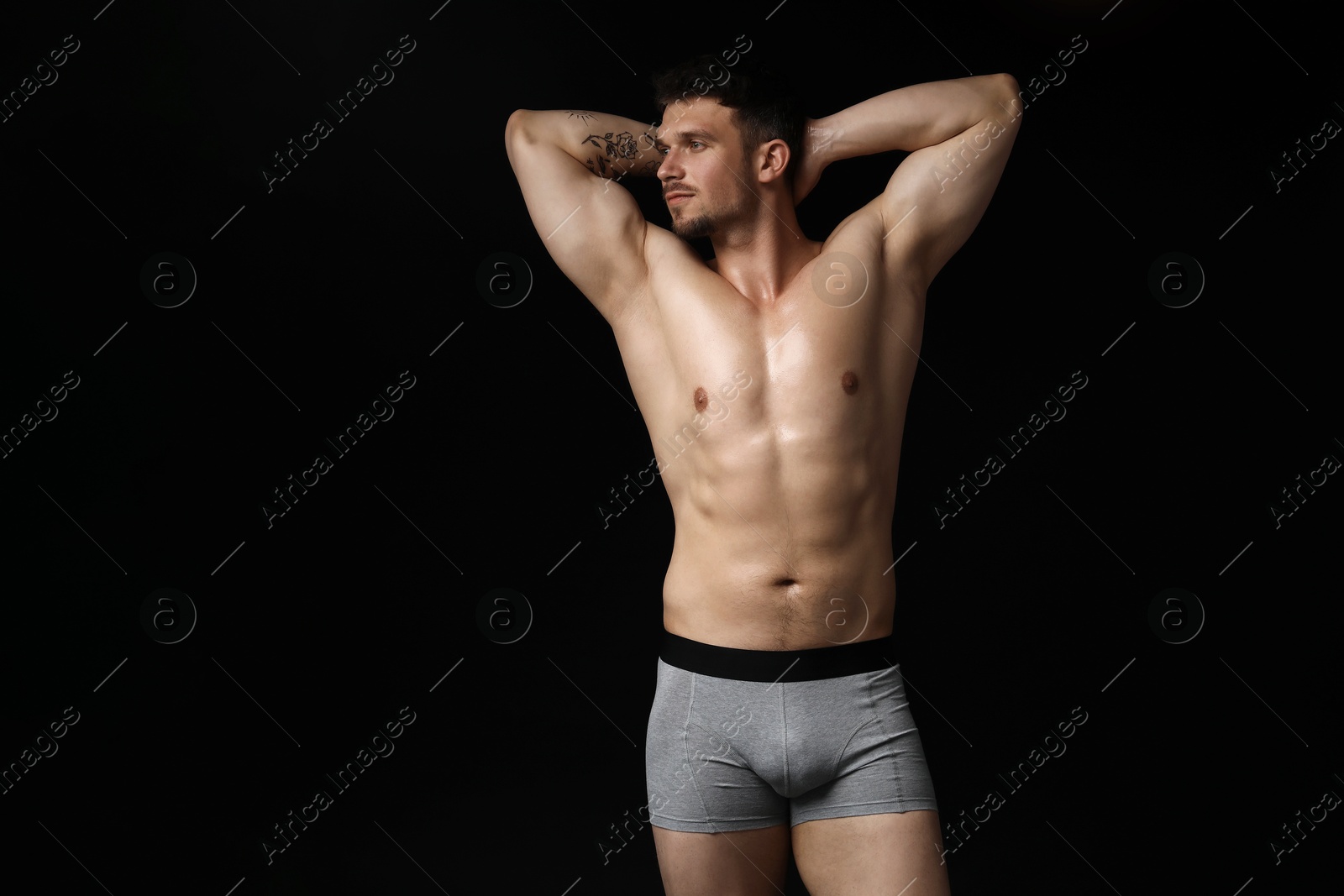 Young man in stylish light grey underwear on black background. Space for text Photo of Young man in stylish light grey underwear on black background. Space for text
