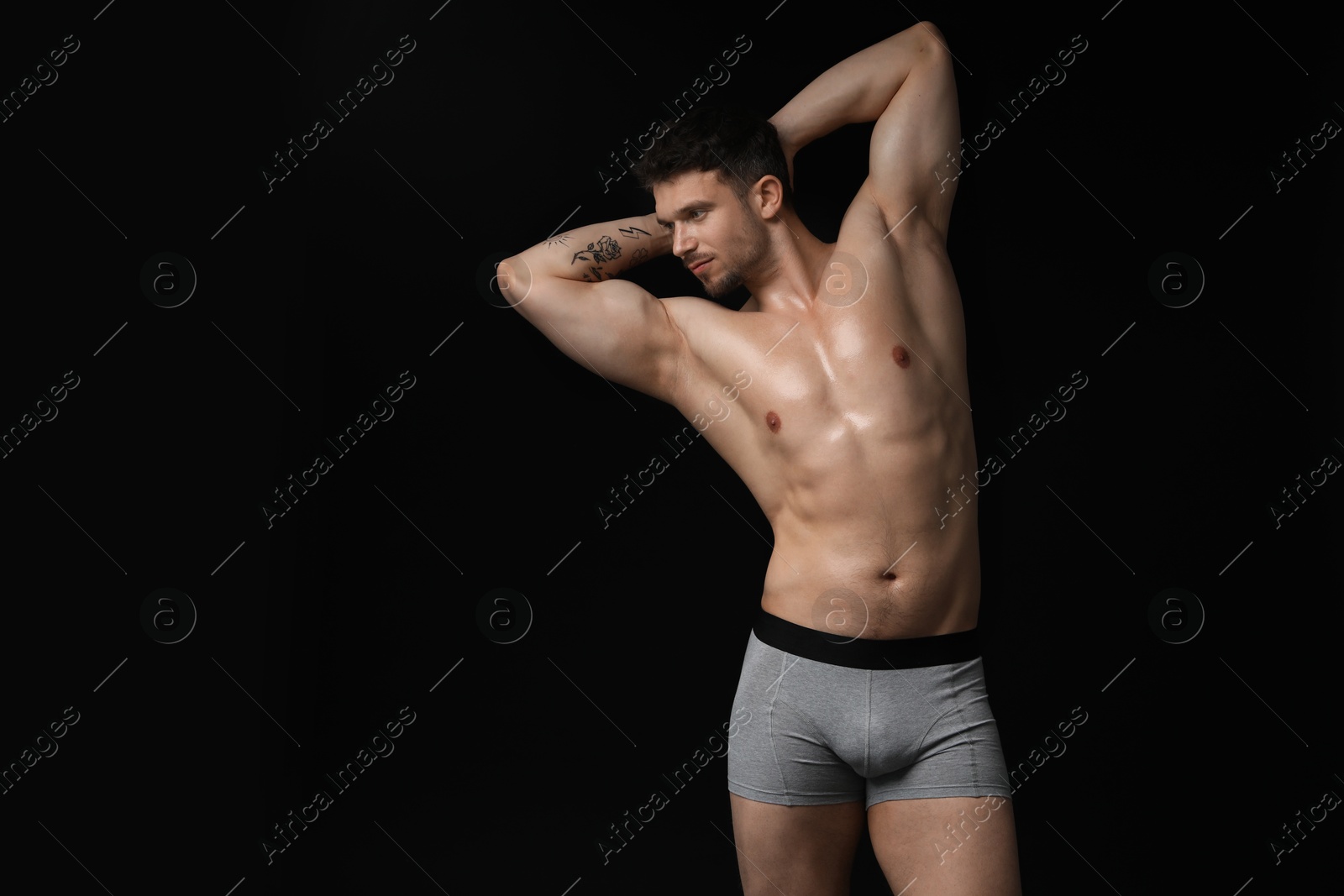Young man in stylish light grey underwear on black background. Space for text Photo of Young man in stylish light grey underwear on black background. Space for text
