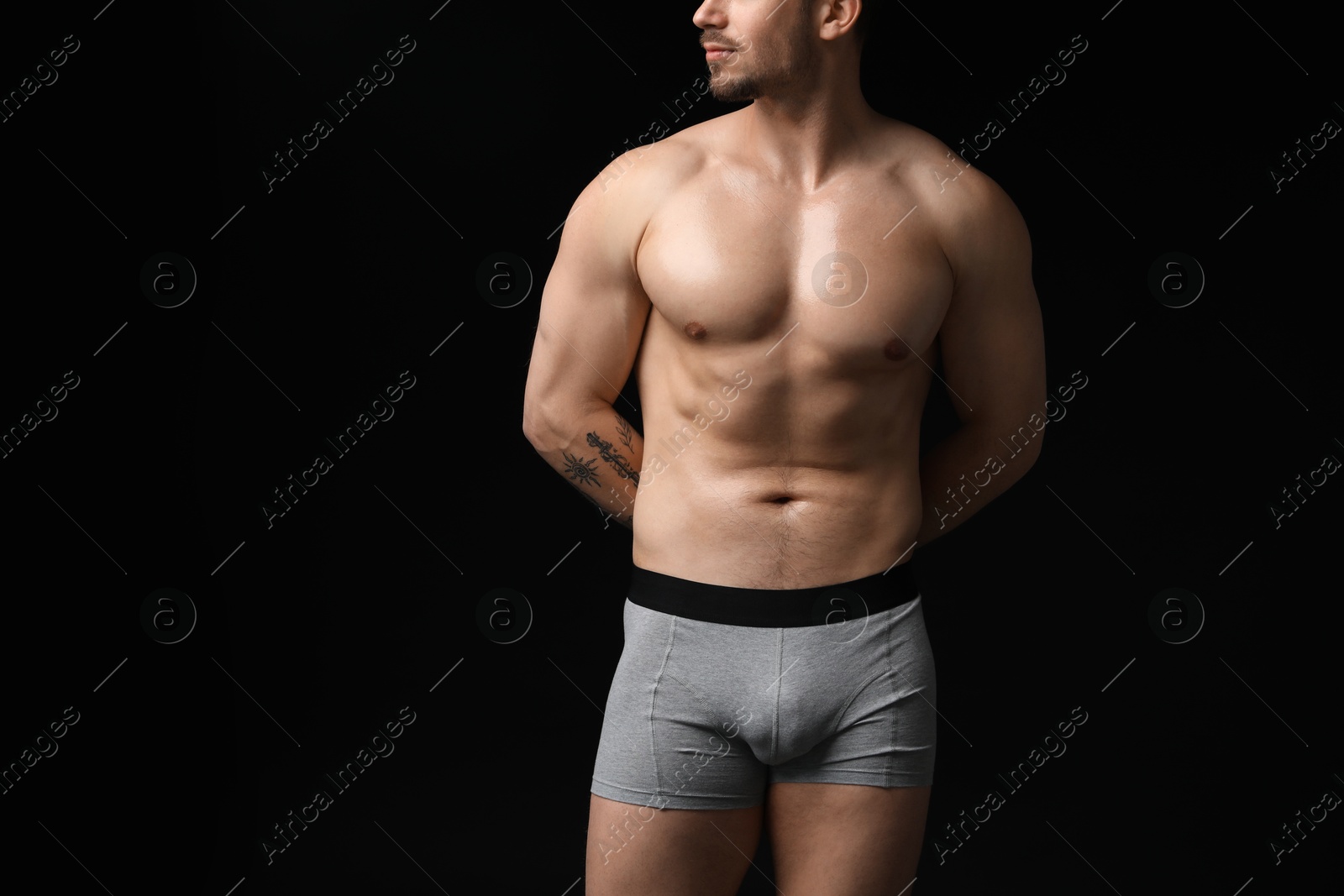 Young man in stylish light grey underwear on black background, closeup Photo of Young man in stylish light grey underwear on black background, closeup