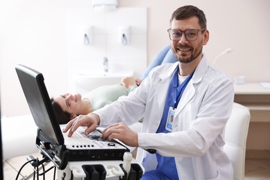 Photo of Sonographer with ultrasound machine and woman waiting for examination in clinic, selective focus