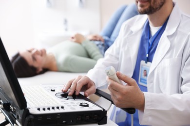 Photo of Sonographer with ultrasound transducer and woman waiting for examination in clinic, selective focus