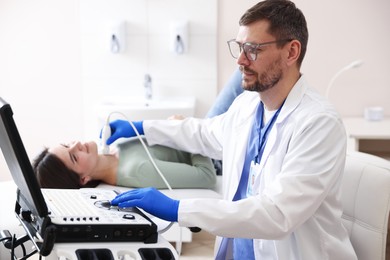 Photo of Sonographer conducting ultrasound examination of woman's thyroid gland in clinic