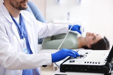 Photo of Sonographer conducting ultrasound examination of woman's thyroid gland in clinic, closeup