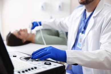 Photo of Sonographer conducting ultrasound examination of woman's thyroid gland in clinic, closeup