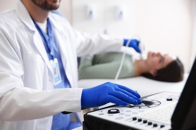 Photo of Sonographer conducting ultrasound examination of woman's thyroid gland in clinic, closeup
