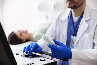 Photo of Sonographer with ultrasound transducer and woman waiting for examination in clinic, selective focus