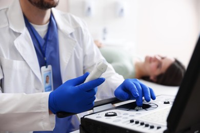 Photo of Sonographer with ultrasound transducer and woman waiting for examination in clinic, selective focus