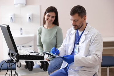 Photo of Sonographer consulting woman before her ultrasound examination in clinic