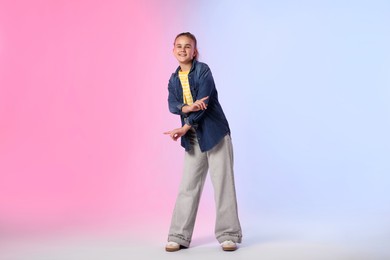 Photo of Girl in stylish clothes dancing on color background
