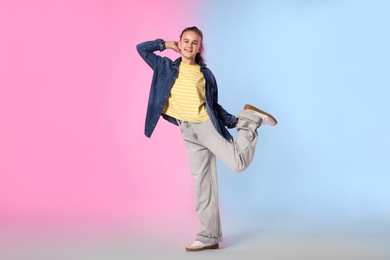 Photo of Girl in stylish clothes dancing on color background