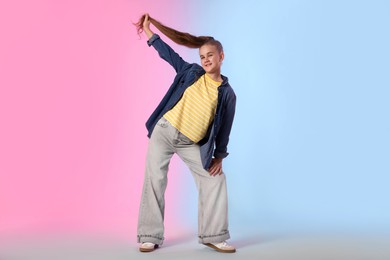 Photo of Girl in stylish clothes dancing on color background