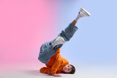Photo of Boy in stylish clothes dancing on color background
