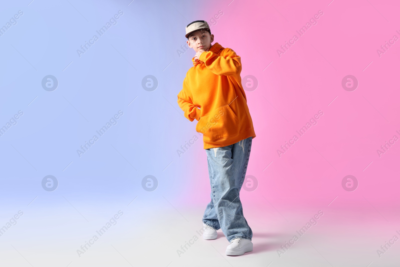 Boy in stylish clothes dancing on color background, space for text Photo of Boy in stylish clothes dancing on color background, space for text