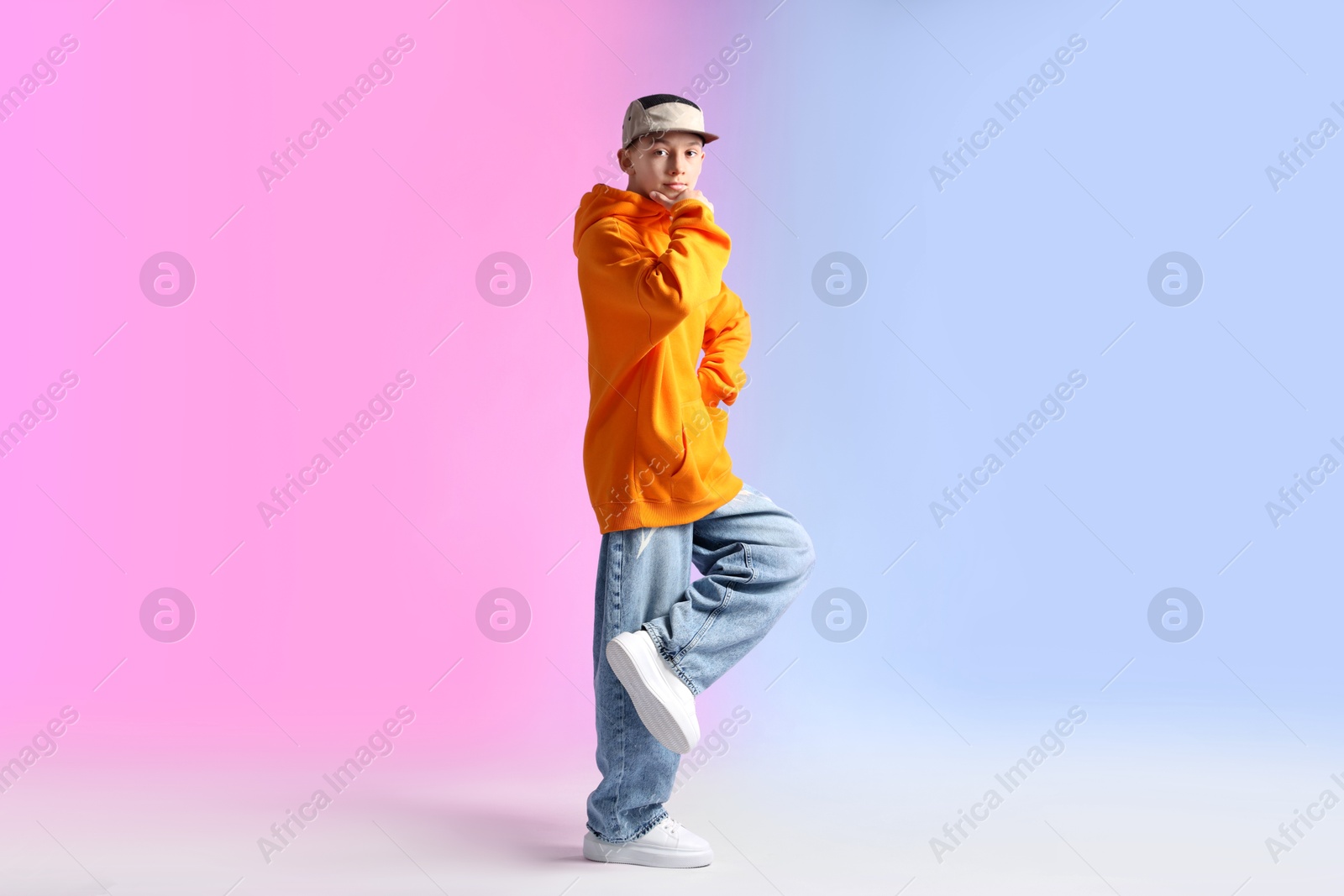 Boy in stylish clothes dancing on color background Photo of Boy in stylish clothes dancing on color background