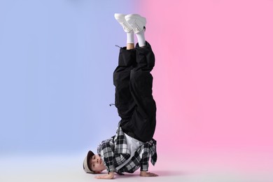 Photo of Boy in stylish clothes dancing on color background