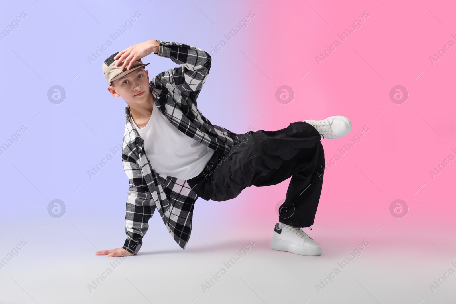Boy in stylish clothes dancing on color background Photo of Boy in stylish clothes dancing on color background