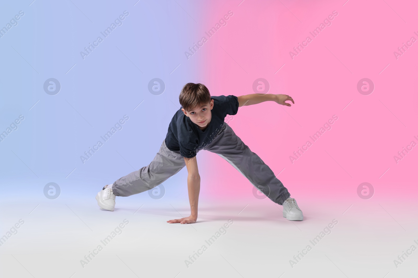 Boy in stylish clothes dancing on color background Photo of Boy in stylish clothes dancing on color background