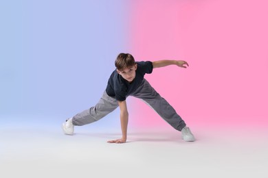 Photo of Boy in stylish clothes dancing on color background