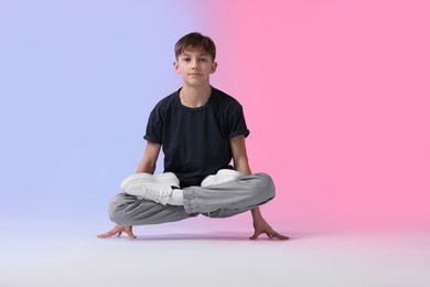 Photo of Boy in stylish clothes dancing on color background