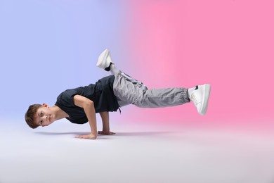 Photo of Boy in stylish clothes dancing on color background
