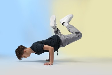 Photo of Boy in stylish clothes dancing on color background