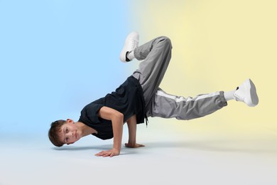 Photo of Boy in stylish clothes dancing on color background